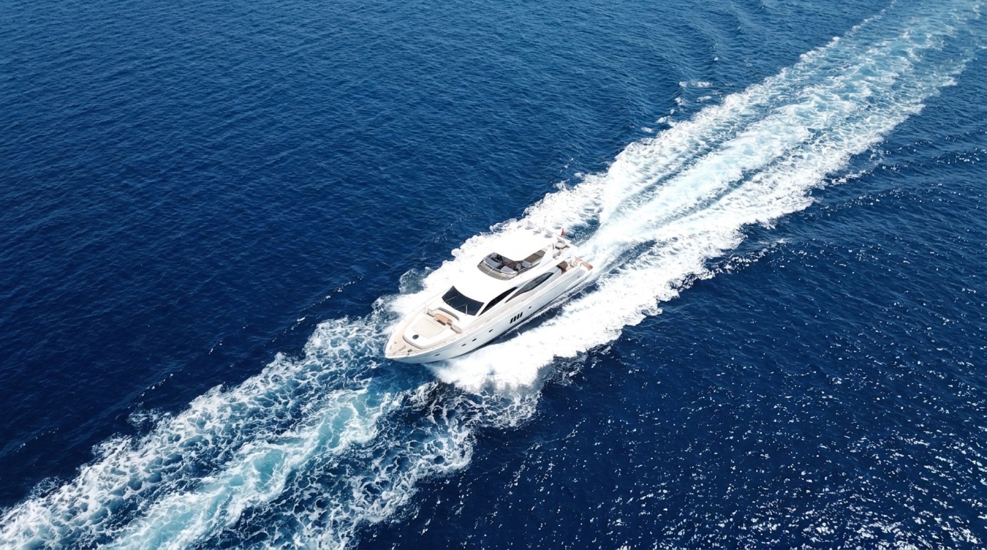 Aerial view of a motor yacht cruising across deep blue water